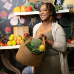 photo gallery image. Wellspire owner holding basket of fruits